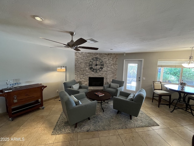 8355 E Via De Encanto, Scottsdale, AZ 85258 - living room featuring a ceiling fan, a textured ceiling, light tile patterned floors, and a fireplace
