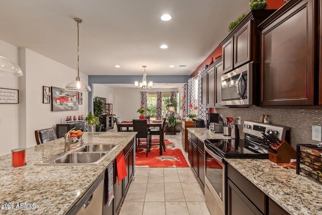 kitchen with a sink, stainless steel appliances, pendant lighting, backsplash, and recessed lighting