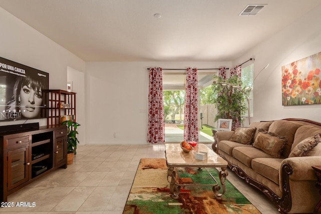 living room featuring a healthy amount of sunlight, visible vents, baseboards, and light tile patterned flooring