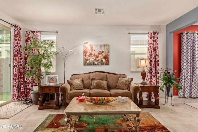 living room featuring a wealth of natural light, visible vents, and light tile patterned floors