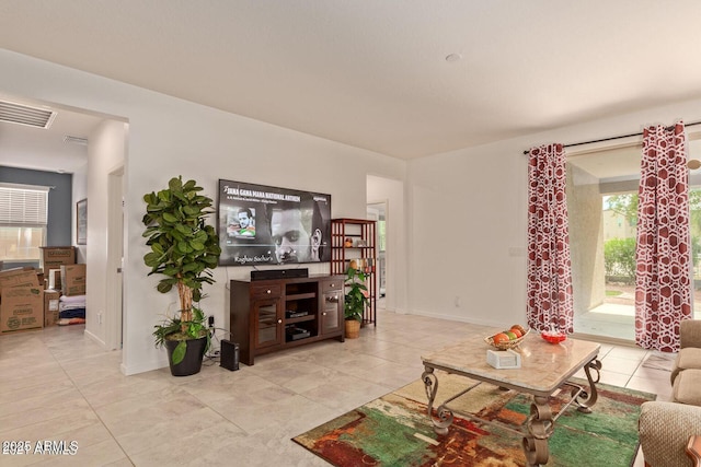 living area featuring visible vents, baseboards, and light tile patterned floors