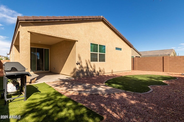 rear view of property featuring a patio area, a fenced backyard, and stucco siding