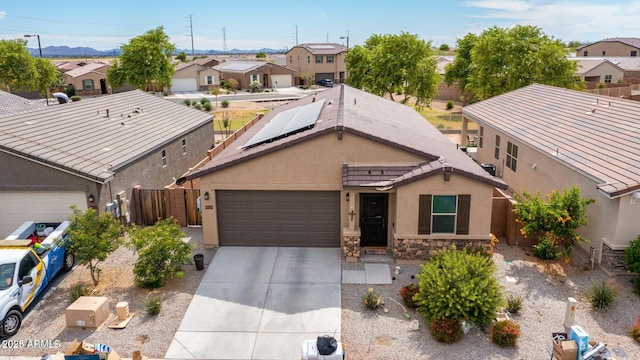 ranch-style home with concrete driveway, stone siding, a residential view, fence, and stucco siding