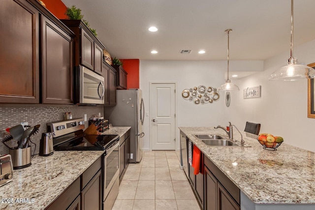 kitchen featuring visible vents, decorative backsplash, an island with sink, appliances with stainless steel finishes, and a sink