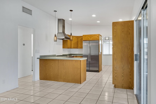 kitchen with kitchen peninsula, pendant lighting, stainless steel fridge, light tile patterned floors, and ventilation hood