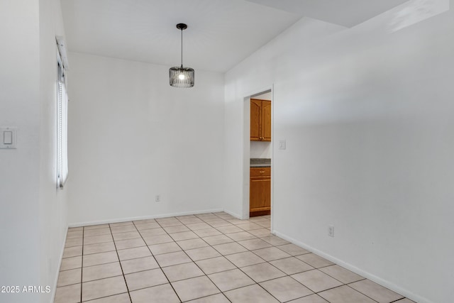 empty room with light tile patterned flooring and a healthy amount of sunlight