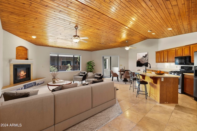 living room featuring wood ceiling, vaulted ceiling, sink, and ceiling fan