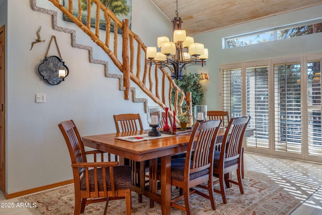 dining space featuring light hardwood / wood-style floors, a chandelier, and wood ceiling