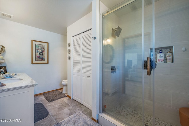 bathroom featuring vanity, a shower with shower door, and toilet