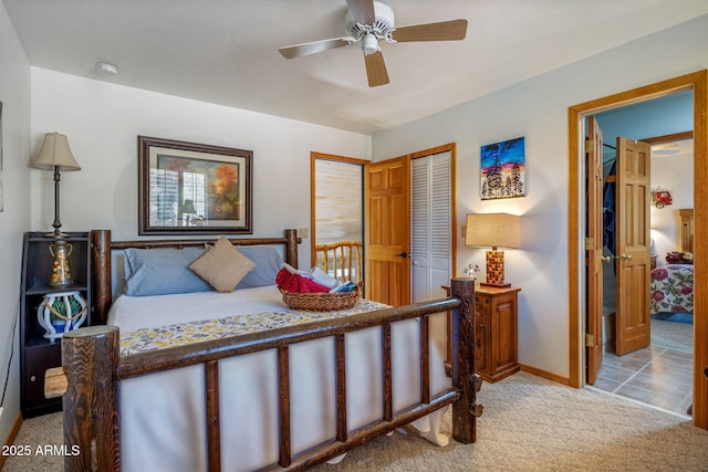 bedroom with ceiling fan, light colored carpet, and a closet