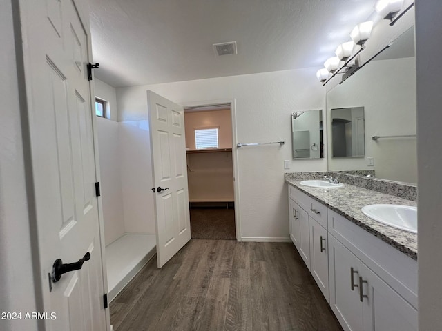 bathroom featuring vanity, hardwood / wood-style flooring, a shower, and a textured ceiling