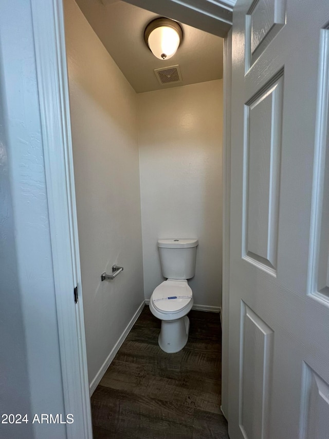 bathroom featuring wood-type flooring and toilet