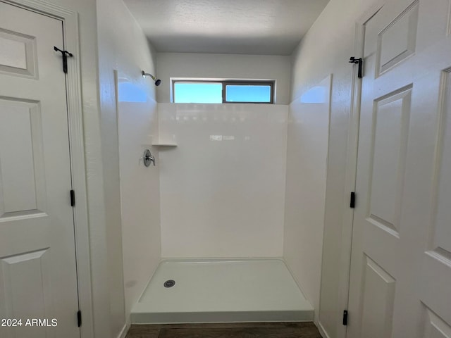 bathroom featuring a shower and a textured ceiling