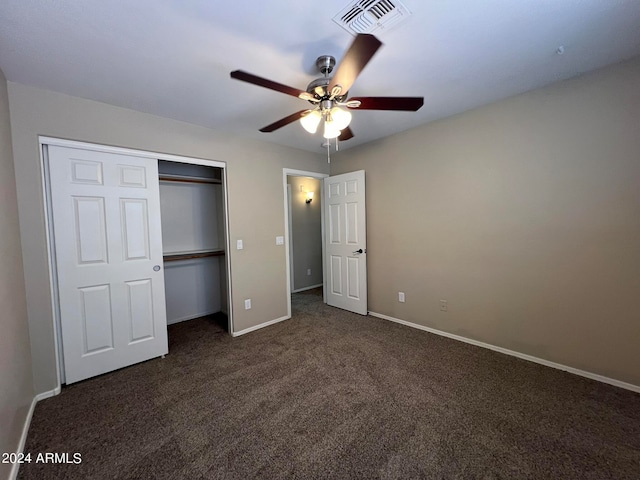 unfurnished bedroom featuring ceiling fan, a closet, and dark colored carpet