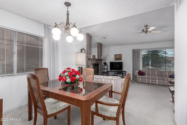 dining room with light colored carpet, a brick fireplace, a textured ceiling, and vaulted ceiling