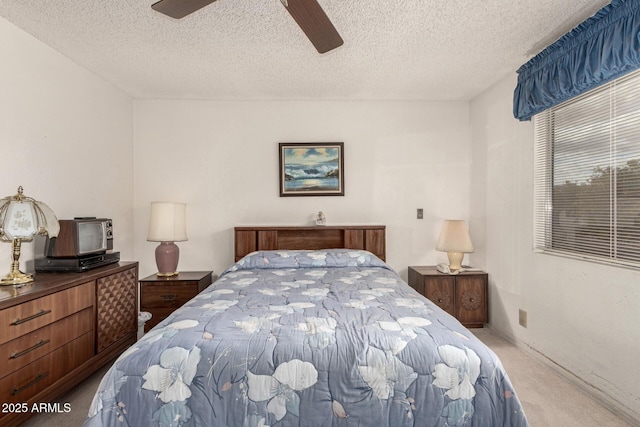 carpeted bedroom with a textured ceiling and ceiling fan