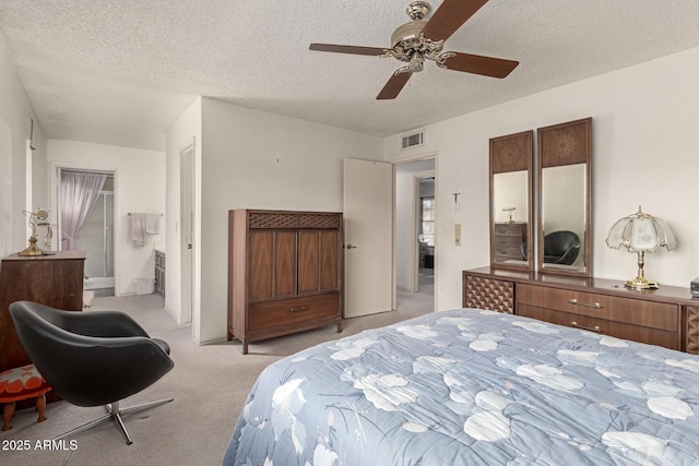 bedroom with visible vents, light colored carpet, ceiling fan, and a textured ceiling