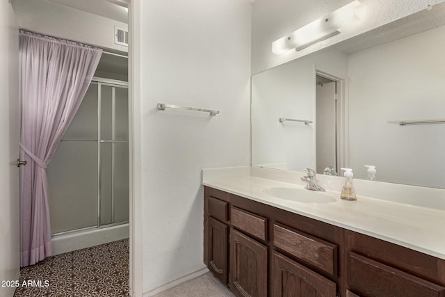 full bath with vanity, visible vents, and a stall shower