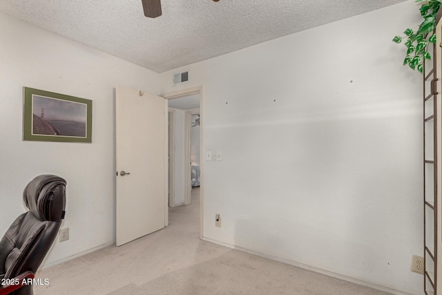 office space featuring visible vents, baseboards, a textured ceiling, and ceiling fan