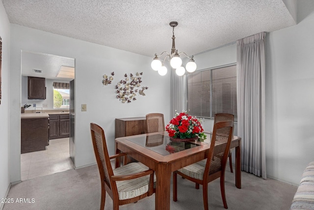 dining room featuring light carpet, a textured ceiling, a chandelier, and light tile patterned flooring