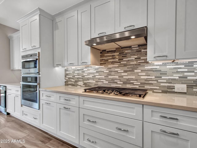 16881 W Merrell St, Goodyear, AZ 85395 - kitchen featuring stainless steel appliances, ventilation hood, light countertops, and wine cooler