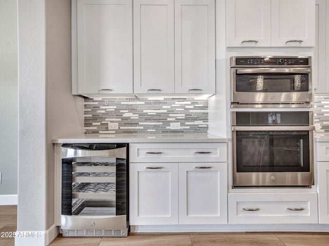 16881 W Merrell St, Goodyear, AZ 85395 - kitchen with beverage cooler, stainless steel double oven, and white cabinets