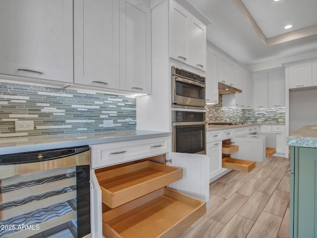 16881 W Merrell St, Goodyear, AZ 85395 - kitchen featuring wine cooler, appliances with stainless steel finishes, light countertops, white cabinetry, and tasteful backsplash