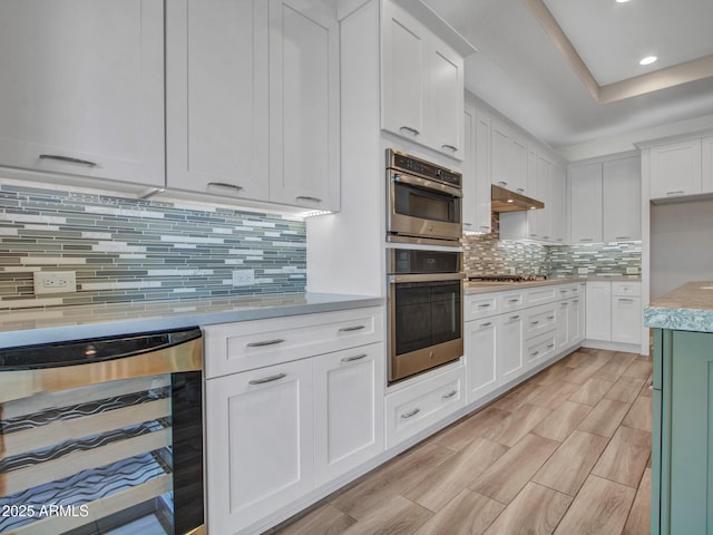 16881 W Merrell St, Goodyear, AZ 85395 - kitchen with beverage cooler, appliances with stainless steel finishes, light countertops, white cabinets, and decorative backsplash