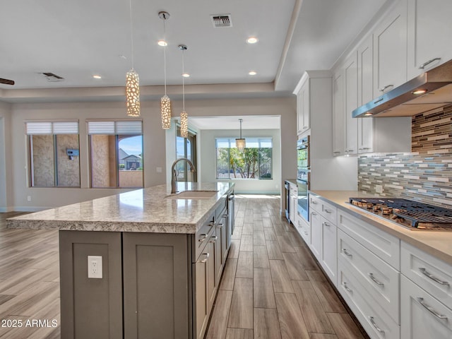 16881 W Merrell St, Goodyear, AZ 85395 - kitchen featuring stainless steel appliances, wood finished floors, backsplash, white cabinets, and recessed lighting
