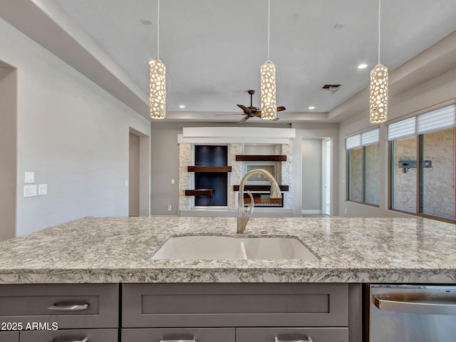 16881 W Merrell St, Goodyear, AZ 85395 - kitchen with a glass covered fireplace, stainless steel dishwasher, gray cabinetry, a sink, and ceiling fan