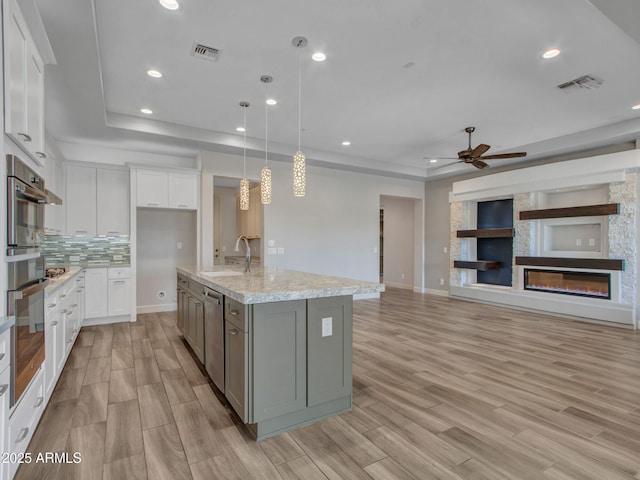 16881 W Merrell St, Goodyear, AZ 85395 - kitchen with a tray ceiling, a sink, open floor plan, appliances with stainless steel finishes, and recessed lighting