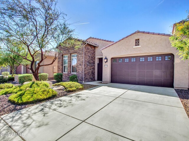 16881 W Merrell St, Goodyear, AZ 85395 - mediterranean / spanish house featuring an attached garage, concrete driveway, stucco siding, and a tiled roof