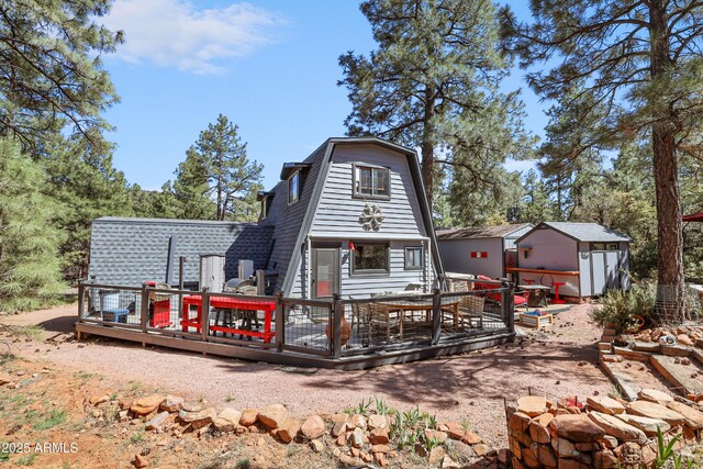 4872 N Trails End Dr, Pine, AZ 85544 - back of house featuring a gambrel roof, a deck, a storage shed, and an outdoor structure