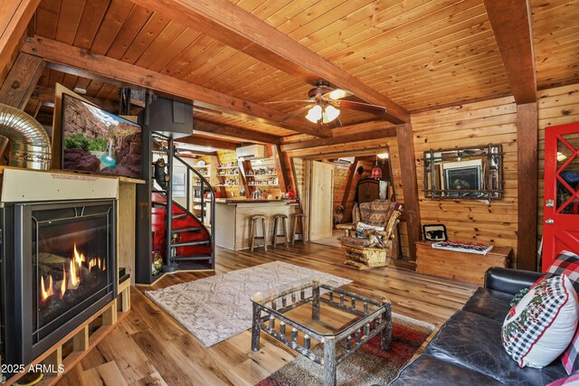 4872 N Trails End Dr, Pine, AZ 85544 - living room with wooden walls, beam ceiling, wood finished floors, a warm lit fireplace, and wooden ceiling