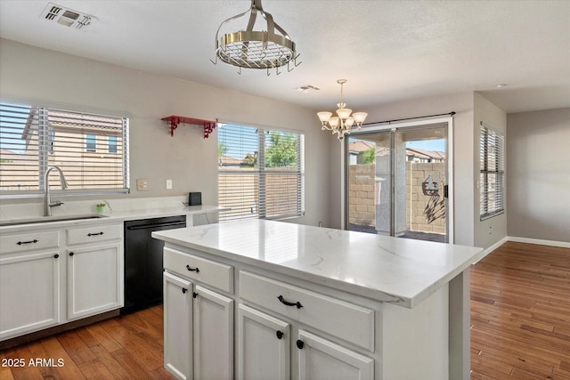 7500 E Deer Valley Rd Unit 54, Scottsdale, AZ 85255 - kitchen with dishwasher, a sink, a chandelier, hardwood / wood-style flooring, and white cabinetry