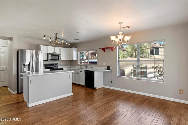 7500 E Deer Valley Rd Unit 54, Scottsdale, AZ 85255 - kitchen featuring a chandelier, appliances with stainless steel finishes, light countertops, and dark wood-type flooring
