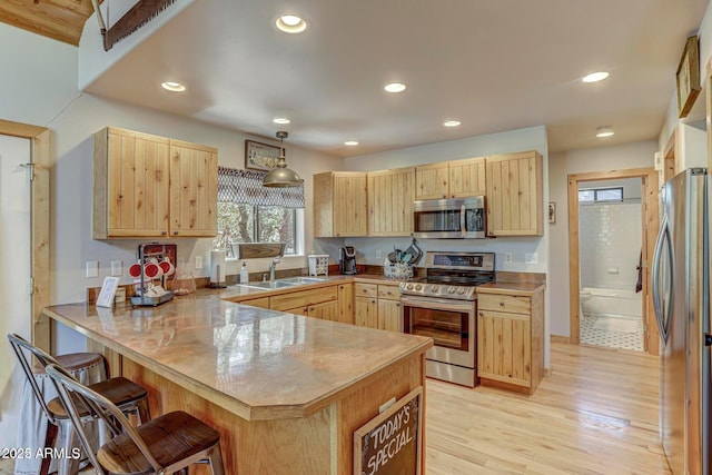 6124 W Hidden Pines Loop, Pine, AZ 85544 - kitchen with stainless steel appliances, light brown cabinets, a peninsula, a kitchen breakfast bar, and recessed lighting