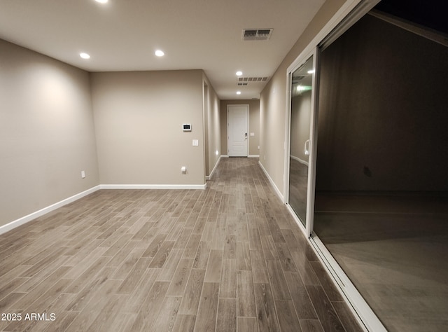 corridor featuring baseboards, wood finished floors, visible vents, and recessed lighting