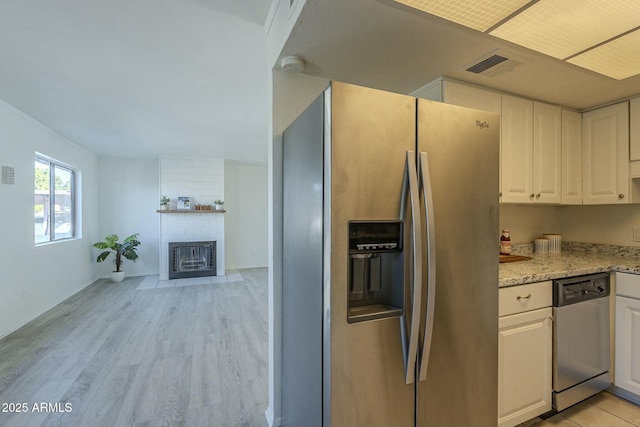 kitchen with white cabinetry, stainless steel appliances, light stone countertops, and light hardwood / wood-style floors