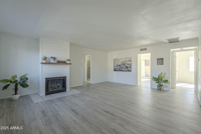 unfurnished living room featuring a fireplace and light hardwood / wood-style flooring