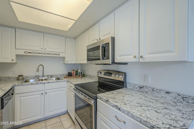 kitchen featuring stainless steel appliances, white cabinetry, sink, and light tile patterned flooring