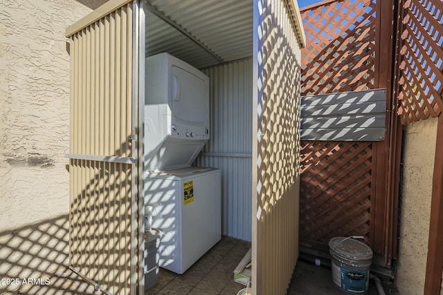 washroom featuring stacked washer / drying machine