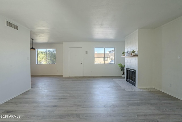 unfurnished living room featuring a fireplace and light hardwood / wood-style flooring