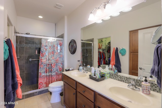 bathroom featuring tile patterned flooring, vanity, an enclosed shower, and toilet