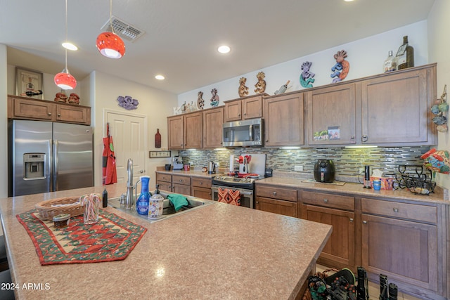 kitchen with decorative backsplash, pendant lighting, stainless steel appliances, and a kitchen island with sink