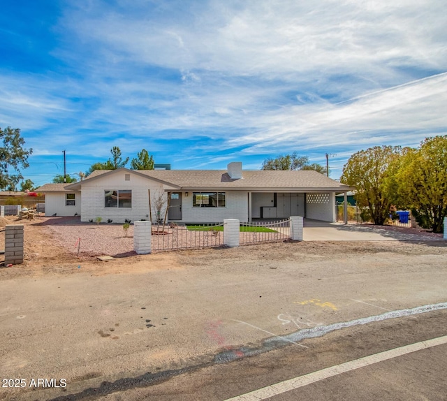 single story home featuring a fenced front yard, an attached carport, concrete driveway, and brick siding