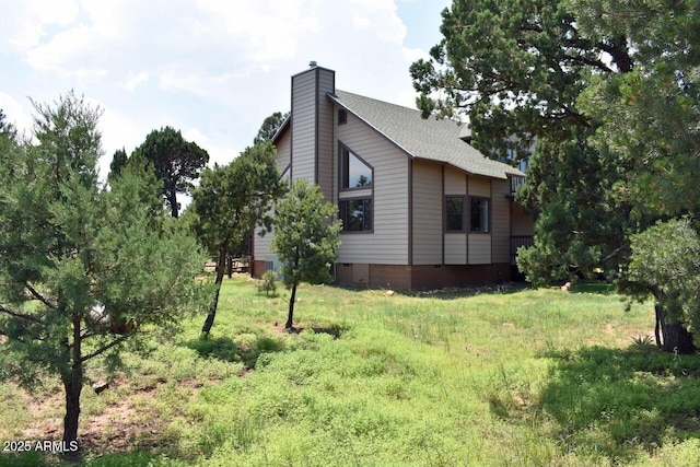 view of property exterior with a chimney and a shingled roof