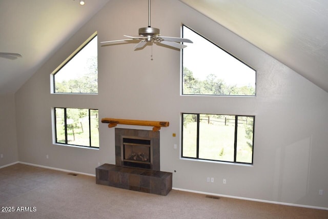 unfurnished living room featuring visible vents, ceiling fan, carpet flooring, and a tile fireplace
