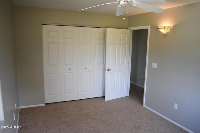 unfurnished bedroom featuring baseboards, a closet, ceiling fan, and carpet