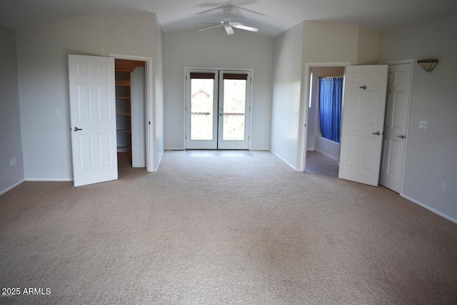 unfurnished bedroom with carpet floors, baseboards, lofted ceiling, and access to exterior